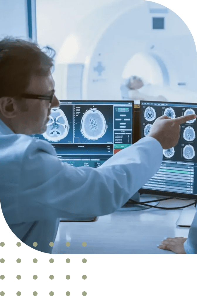 Doctor analyzing brain scans on multiple monitors in a lab.