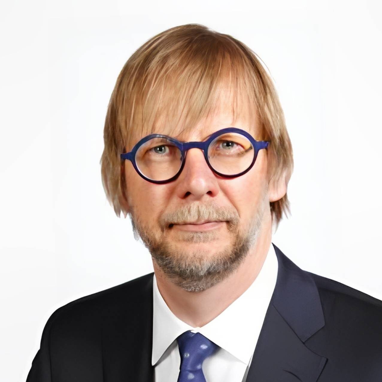 Professional man with blond hair and round glasses in a suit.